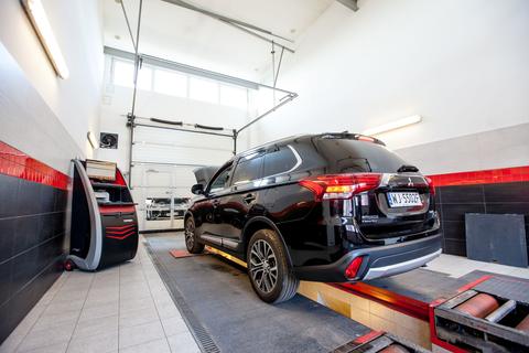 Ciemny samochód na linii diagnostycznej w stacji kontroli pojazdów CarPoint